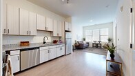 Located on Nolensville Road in Nashville, TN, this thoughtfully designed 2-bedroom, 1-bathroom residence offers a modern, open-concept layout across a single floor. Light-toned luxury vinyl plank flooring extends through the main living areas, creating a cohesive and airy feel throughout.

The kitchen is a standout feature, equipped with a full suite of stainless steel appliances including a range, microwave, dishwasher, and refrigerator. Light wood cabinetry with matte black hardware pairs with granite countertops and a double basin sink to deliver a clean, contemporary aesthetic. The kitchen flows seamlessly into the living area, which benefits from large windows that invite generous natural light.

The living room provides a comfortable, open space with room for varied furniture arrangements, while a large multi-pane window serves as a focal point, framing views of the exterior. Soft carpet underfoot distinguishes the living zone from the hard-surface entry and kitchen areas.

The primary bedroom features plush carpeting, a sizeable window for natural light, and notable ceiling height that enhances the sense of space. The full bathroom is finished with wood-look vinyl flooring, a granite-topped vanity with light cabinetry, and a tiled shower-tub combination. The second bedroom offers comparable comfort and natural light.
