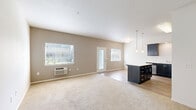 Located at 2300 Main St in Washougal, WA, this single-floor 2-bedroom, 2-bathroom residence offers a thoughtfully designed layout that balances functionality and comfort. The open-concept kitchen and living area serves as the heart of the home, showcasing rich dark cabinetry, white quartz countertops, stainless steel appliances, a central island with pendant lighting, and wood-style flooring that ties the space together seamlessly. Natural light filters through windows into the adjoining living area, creating a bright and welcoming atmosphere.

Both bedrooms feature soft wall-to-wall carpeting and windows with blinds that frame views of the surrounding greenery. The primary bedroom includes a ceiling fan and a double sliding-door closet, providing ample storage. The second bedroom is equipped with a wall-mounted HVAC unit for individualized climate control. Each bedroom is accessed via a connecting hallway that ensures a logical and private flow through the home.

The two bathrooms are finished with dark vanity cabinetry, light countertops, and full tub-shower combinations. One bathroom also features built-in shelving for additional storage. Clean white walls and neutral flooring throughout maintain a cohesive and move-in-ready aesthetic.