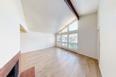 Located at 16910 NE 80th St in Redmond, WA, this single-floor, 2-bedroom, 1-bathroom home offers a thoughtfully laid-out interior with a welcoming ambiance throughout. The living room is a standout space, featuring dramatic vaulted ceilings with an exposed wood beam, a classic brick fireplace with a tile hearth, and a generous wall of windows that floods the room with natural light and frames outdoor views. Light-toned hardwood-style flooring runs throughout the home, complementing the bright, neutral color palette. The kitchen is well-appointed with warm honey-toned wood cabinetry, sleek stone countertops, stainless steel appliances including a refrigerator and range, and a peninsula that opens toward the dining area—ideal for everyday functionality. A central hallway connects the main living areas to the two bedrooms, each offering ample natural light through large windows with outdoor views. The full bathroom features a rich wood vanity, light countertops, and hardwood-style flooring. Four closets provide excellent storage throughout. A patio extends the living space outdoors, perfect for enjoying the Pacific Northwest setting. The textured ceilings and consistent finishes give this home a cohesive, updated feel.