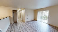Located in Auburn, WA, this well-designed 4-bedroom, 2-bathroom unit offers a comfortable and functional single-floor layout. The open living room is bright and welcoming, featuring light wood-style vinyl plank flooring, neutral walls, and a sliding glass door fitted with vertical blinds that allows natural light to flow in and provides access to an outdoor area. Adjacent to the living room, the galley-style kitchen is efficiently laid out with light wood cabinetry, dark granite-style countertops, a double sink, and black appliances including a refrigerator, electric range, microwave, and dishwasher. A breakfast bar separates the kitchen from the living space, enhancing the open feel. The four bedrooms are carpeted and each features a window with blinds and a baseboard heater, providing warmth and natural light. The primary bedroom is generously sized and includes a walk-in closet outfitted with wire shelving for ample storage. The two bathrooms are finished with wood-toned cabinetry, dark countertops, and wood-style flooring. One bathroom features a combination tub and shower with tile surround, along with built-in wire shelving for added convenience. A dedicated closet provides additional storage throughout the unit.