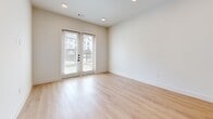 Located at 4700 Fossil Vista Dr in Haltom City, TX, this well-appointed one-bedroom, one-bathroom residence offers a thoughtfully designed layout with modern finishes throughout. Light-toned hardwood flooring runs continuously across the entire space, creating a cohesive and airy feel.

The open-concept kitchen and living area serves as the heart of the home. The kitchen features a large central island with a crisp white quartz countertop and an integrated sink, complemented by a striking combination of white upper cabinets and natural wood-toned lower cabinetry. Stainless steel appliances, including a side-by-side refrigerator with ice and water dispenser, add a sleek, contemporary touch. Pendant lighting above the island provides focused illumination alongside recessed ceiling lights.

The living area opens to the outdoors through a set of French doors, allowing generous natural light and outdoor views. The bedroom is a comfortable, well-proportioned room with a large window framing neighborhood views. A dedicated walk-in closet with dual hanging rods and shelving offers practical storage.

The full bathroom is elongated and functional, showcasing natural wood vanity cabinetry with white quartz countertops, matte black hardware and fixtures, a framed mirror, and a tiled tub-shower combination. Clean white walls and recessed lighting complete the modern aesthetic throughout.