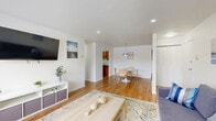 Located at 587 Broadway in Menands, NY, this well-appointed one-bedroom, one-bathroom unit offers a thoughtfully designed layout across a single floor. Warm hardwood flooring flows throughout the main living areas, creating a cohesive and inviting atmosphere. The open-concept living and dining area is bright and airy, with recessed lighting and a large picture window that fills the living room with natural light and outdoor views. A second dining nook, illuminated by a modern pendant light, provides a cozy spot for everyday meals. The galley-style kitchen is efficiently designed with rich wood cabinetry, granite countertops, white subway tile backsplash, and stainless steel appliances, offering ample storage and workspace. The spacious primary bedroom features hardwood floors, a generous louvered closet, a wall-mounted unit, and a window overlooking the surrounding landscape. The full bathroom is finished with a wood-framed vanity, granite countertop, mosaic tile flooring, and a tub/shower combination. Additional storage is available via a dedicated closet with built-in shelving. Clean white walls and recessed lighting throughout lend the space a fresh, modern feel.