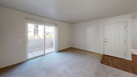 Located in Cameron Park, CA, this three-bedroom, one-bathroom unit offers a practical and well-organized single-floor layout. The spacious primary bedroom features plush carpeting, a sliding glass door opening to a private patio with outdoor views, and access to a generously sized walk-in closet complete with built-in shelving and hanging rods. The two additional bedrooms are also carpeted and filled with natural light from windows overlooking the surrounding greenery. The kitchen is equipped with white cabinetry trimmed in wood tones, a full suite of appliances including a range, refrigerator, and dishwasher, and durable hardwood-style flooring that extends through the main living areas and hallways. A dedicated laundry area provides washer and dryer hookups along with overhead shelving for added storage convenience. The full bathroom includes a shower-tub combination with chrome fixtures and hardwood-style flooring. Throughout the unit, neutral wall tones and clean lines create a bright, move-in-ready atmosphere. Sliding glass patio doors in multiple rooms allow for abundant natural light and easy outdoor access, enhancing the overall sense of openness within the home.
