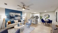 Located at 99 Ascension Dr in Asheville, NC, this well-appointed 2-bedroom, 2-bathroom residence is designed for comfortable, modern living on a single floor. The open-concept main area seamlessly connects the living room, dining area, and kitchen, all unified by light wood-style flooring throughout. The living room features a ceiling fan, a bold navy accent wall, and a bright window that brings in natural light. The kitchen is outfitted with stainless steel appliances, granite-style countertops, white cabinetry, and a peninsula with bar seating — ideal for casual dining or entertaining. A dedicated dining area offers additional space for meals and gatherings. The primary bedroom makes a statement with a deep navy accent wall, ceiling fan, and natural light. The second bedroom is bright and inviting, with closet access and its own ceiling fan. A walk-in closet provides generous storage with wire shelving. Both bathrooms are finished with tile surrounds and tub-shower combinations. A dedicated laundry room with wire shelving adds everyday convenience. The cohesive blue-and-neutral color palette gives the entire space a polished, contemporary feel.