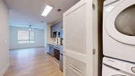 Located at 4200 N Carlin Springs Rd in Arlington, VA, this one-bedroom, one-bathroom unit offers a thoughtfully designed layout across a single floor. The open-concept living and dining area is bright and airy, highlighted by light wood-style flooring, a ceiling fan, and a large window that invites natural light and outdoor views. The modern kitchen is a standout feature, showcasing sleek gray cabinetry with matte black hardware, white quartz countertops, a white subway tile backsplash, and a full suite of stainless steel appliances including a refrigerator, electric range, and over-the-range microwave. A matte black spring-neck faucet adds a contemporary accent to the undermount sink. The bedroom is carpeted for comfort, features a window with exterior views, and includes a sliding double-panel closet for convenient storage. The bathroom is finished with large-format tile flooring, a gray vanity with black fixtures, and a tub-shower combination with marble-look tile surround. An in-unit laundry area and dedicated closet space add to the unit's practical appeal. The clean, neutral palette and modern finishes throughout create a cohesive and move-in-ready living environment.