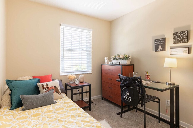 Experience the comfort and charm of this inviting bedroom, perfect for relaxation and study. - Oxford West Apartments