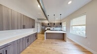 Located at 18 Lane Ave in Caldwell, NJ, this thoughtfully designed single-floor residence offers four bedrooms and two full bathrooms across a well-proportioned layout. The open-concept kitchen is a standout feature, showcasing sleek wood-grain cabinetry with matte black hardware, bright white quartz countertops, stainless steel appliances, and a large center island ideal for dining or entertaining. Stylish pendant lighting and exposed industrial ductwork add a modern, loft-inspired character throughout. Light hardwood floors flow seamlessly across the entire residence, enhancing the sense of openness and continuity. The living area benefits from natural light through multiple windows dressed with neutral blinds. The generously sized primary bedroom offers ample space and natural light, while the additional bedrooms are well-proportioned with windows overlooking the neighborhood. Both bathrooms are finished to a high standard, featuring large-format dark tile flooring, glass-enclosed walk-in showers with matte black fixtures, and vanities with white countertops. One bathroom also includes built-in open shelving for added storage. The overall aesthetic is clean, contemporary, and move-in ready, making this Caldwell residence a refined and functional home.