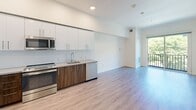 Located in the heart of downtown Sacramento at 1517 H Street, this well-designed one-bedroom, one-bathroom residence offers a smartly utilized single-floor layout. The open-concept living and kitchen area is anchored by light hardwood-style flooring and recessed lighting, creating a bright, cohesive space. A sliding glass door leads to a private balcony, allowing natural light to flow into the main living area.

The modern kitchen is a standout feature, outfitted with two-tone cabinetry — warm wood lower cabinets paired with crisp white upper cabinets — complemented by a light tile backsplash and quartz countertops. Stainless steel appliances include a French door refrigerator with ice and water dispenser, electric range, built-in microwave, and dishwasher, making it fully equipped for everyday living.

The bedroom features neutral carpet and clean white walls, offering a calm and functional retreat. The bathroom is finished with marble-look surround tiling in the tub/shower combo, light wood-style flooring, a wood-framed vanity with a white quartz countertop, and a large mirror, delivering a polished, contemporary aesthetic throughout. The unit also includes an in-unit washer and dryer for added convenience.