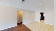 Located at 7913 Palmera Pointe Cir in Tampa, Florida, this single-story home offers a well-organized layout with a variety of functional spaces throughout. The main living area features a combination of rich hardwood-style flooring and light ceramic tile, creating a clear visual distinction between the living and dining zones. Recessed lighting and a textured ceiling add to the clean, neutral aesthetic throughout the common areas. The kitchen is thoughtfully appointed with dark espresso cabinetry, granite countertops, a dark tile backsplash, and stainless steel appliances including a refrigerator and range. A window above the sink allows natural light to brighten the workspace. The living room opens to a large sliding glass door dressed with vertical blinds, filling the room with additional natural light. Bedrooms are carpeted for comfort and include windows with blinds. One bedroom benefits from a walk-in closet with built-in shelving and direct access to an en suite bathroom. The bathrooms mirror the kitchen's design language, featuring dark cabinetry, granite vanity tops, and tile flooring. Throughout the home, neutral wall tones and consistent finishes create a cohesive, move-in-ready environment suitable for a range of lifestyles.