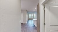This 1,330-square-foot, single-floor apartment at Peridot Palms (Unit 5102-C2) features 3 bedrooms, 2 bathrooms, and a thoughtfully designed open layout. The kitchen is a standout, boasting contemporary wood-tone cabinetry, a mosaic tile backsplash with accent lighting, quartz countertops, stainless steel appliances, and a large center island — seamlessly connected to the living area. Wood-look luxury vinyl flooring runs throughout the unit, complemented by neutral walls and abundant natural light through multiple windows fitted with blinds. Ceiling fans are present in the bedrooms and living areas for added comfort. The 200-square-foot primary bedroom includes a dedicated walk-in closet with wire shelving systems. Secondary bedrooms also feature closets with organized shelving. Both bathrooms offer wood-tone vanities with quartz countertops, framed mirrors, and tile flooring; one bathroom includes a tub-shower combination with decorative tile surround. The dedicated laundry room is equipped with a full-size washer and dryer, overhead cabinetry, and a utility sink. A private balcony and ample closet storage across three closets round out this well-appointed residence.