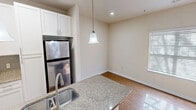 This 760 square foot apartment in Charlotte, NC offers a thoughtful layout maximizing space and functionality. The open-concept design seamlessly integrates the living, dining, and kitchen areas, creating a spacious feel. The modern kitchen boasts white cabinetry, stainless steel appliances, and a granite countertop with a breakfast bar, perfect for casual dining or entertaining.

The two bedrooms feature plush carpeting and ceiling fans, with the primary bedroom measuring a comfortable 150 square feet. Large windows in both rooms provide ample natural light. The bathroom showcases neutral-toned tile work and a full-sized tub/shower combination.

Hardwood flooring throughout the main living areas adds warmth and elegance. The in-unit laundry room offers convenience with full-sized appliances and additional storage space. Practical amenities include blinds on all windows and recessed lighting.

This single-story unit combines modern finishes with a practical layout, ideal for those seeking a contemporary living space in Charlotte's vibrant 28262 zip code.