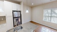 This 760 square foot apartment in Charlotte, NC offers a thoughtful layout maximizing space and functionality. The open-concept design seamlessly integrates the living, dining, and kitchen areas, creating a spacious feel. The modern kitchen boasts white cabinetry, stainless steel appliances, and a granite countertop with a breakfast bar, perfect for casual dining or entertaining.

The two bedrooms feature plush carpeting and ceiling fans, with the primary bedroom measuring a comfortable 150 square feet. Large windows in both rooms provide ample natural light. The bathroom showcases neutral-toned tile work and a full-sized tub/shower combination.

Hardwood flooring throughout the main living areas adds warmth and elegance. The in-unit laundry room offers convenience with full-sized appliances and additional storage space. Practical amenities include blinds on all windows and recessed lighting.

This single-story unit combines modern finishes with a practical layout, ideal for those seeking a contemporary living space in Charlotte's vibrant 28262 zip code.