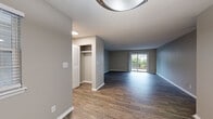Located at 1001 N Natchez Rd in Chattanooga, Tennessee, this single-floor residence offers a well-organized layout with a clean, updated aesthetic throughout. The open living area is finished with dark wood-look flooring and neutral gray walls, creating a modern, cohesive atmosphere. A sliding glass door floods the space with natural light and provides direct access to an outdoor area with greenery views, enhancing the sense of openness. A built-in closet near the entry adds practical storage from the moment you arrive. The kitchen is thoughtfully appointed with white shaker-style cabinetry, white countertops, a subway tile backsplash, a double-basin stainless steel sink, and black appliances including a range, over-the-range microwave, dishwasher, and refrigerator. Wood-look flooring continues seamlessly into this space. The two bedrooms feature plush carpeting and louvered closet doors, offering comfortable, quiet retreats. One bedroom provides convenient access to the in-unit laundry area, which is equipped with a washer and dryer alongside shelving for storage. The bathrooms are finished with white vanities, mirrors, and tiled tub-shower combinations, maintaining a consistent, fresh look throughout the home.