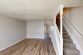 Located at 10530 Florida Blvd in Baton Rouge, Louisiana, this two-story home offers a practical and well-organized layout across two evenly divided floors. The main level features a bright, open living room with warm wood-look hardwood-style flooring, neutral-toned walls, and a textured ceiling. A staircase with a classic white baluster railing connects the floors seamlessly. The kitchen is efficiently designed in a galley style, featuring white cabinetry, dark laminate countertops, a double-basin stainless steel sink, and a white electric range. A pantry and dining area complement the kitchen space, providing added functionality. Three hallways connect the various rooms, enhancing the flow throughout both levels. Upstairs, the two bedrooms are carpeted and feature natural light from large windows with outdoor views. The primary bedroom offers generous proportions with a double-door closet, while the second bedroom also includes multiple closet spaces, providing abundant storage. Six closets in total are distributed throughout the home. Three bathrooms serve the residence, including one with a shower-tub combination. The textured ceilings are consistent throughout, adding a classic character to the overall design of the home.