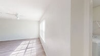 Located in Mariners Cove Court in East Lake, FL, this single-story, 2-bedroom, 2-bathroom home offers a well-organized layout designed for comfortable everyday living. The open-concept living room features light wood-look flooring and a ceiling fan, with a large window that floods the space with natural light, creating a bright and airy atmosphere. The kitchen is positioned adjacent to the living area and is equipped with light wood cabinetry, granite-style countertops, white appliances including a range and refrigerator, and a double-basin sink at the breakfast bar peninsula — a practical and functional setup for cooking and entertaining. Both bedrooms are carpeted and include ceiling fans; one bedroom features a walk-in closet outfitted with wire shelving for generous storage, while the second bedroom includes a standard closet with a louvered door. Each of the two full bathrooms includes a tiled tub-shower combination, wood-look flooring, and a vanity with granite-style countertops. A dedicated in-unit laundry room with a full-size washer and dryer adds significant convenience. The home's clean, neutral palette throughout lends itself to easy personalization and a move-in-ready feel.