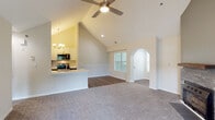 Located at 6801 Chesterbrook Dr in Raleigh, NC, this single-floor residence offers a well-designed layout with contemporary finishes and abundant natural light. The kitchen is appointed with stainless steel appliances, including a range, microwave, and dishwasher, complemented by two-tone cabinetry featuring white upper cabinets and gray lower cabinets, a white quartz countertop, and a pendant light fixture. Large windows overlooking lush greenery allow natural light to fill the dining area adjacent to the kitchen. The open living area features warm wood-look flooring that extends throughout the unit, a ceiling fan, a textured ceiling, and a standout fireplace with a wood mantel set against a two-tone accent wall, adding character to the space. A sliding glass door opens to an outdoor patio with views of the surrounding landscaping. The bedroom offers generous proportions, tall ceilings, and direct access to a walk-in closet with wire shelving, as well as a private bathroom. The bathroom is finished with a gray vanity, white countertop, framed mirror, and brushed nickel lighting fixtures. An in-unit laundry area adds everyday convenience to this thoughtfully updated residence.