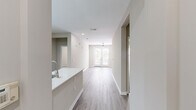 This single-floor, 3-bedroom, 2-bathroom residence offers a thoughtfully designed layout that balances comfort and functionality. The welcoming entrance leads into an open-concept living and kitchen area bathed in natural light. The living room features light wood-look flooring, a ceiling fan, and a set of French doors that open to an outdoor space, creating an airy, connected atmosphere.

The kitchen is well-equipped with white shaker-style cabinetry, a white quartz peninsula countertop with an undermount sink, subway tile backsplash, and stainless steel appliances including a refrigerator, range, microwave, and dishwasher. A skylight above adds additional brightness to the space.

The primary bedroom offers plush carpeting and a generously sized walk-in closet outfitted with multi-tiered wire shelving for ample storage. The en-suite bathroom features a white vanity with quartz countertop, an undermount sink, a large mirror, and a separate glass-enclosed shower. The second full bathroom is similarly finished and includes a tub-shower combination with white tile surround. The two additional bedrooms are carpeted and share neutral warm-toned walls, offering versatile use as sleeping quarters, a home office, or a guest room. Two hallways connect the rooms efficiently, completing this clean, move-in ready layout.