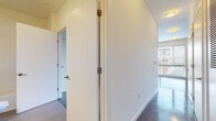 Located at 1255 Chapel St in New Haven, Connecticut, this single-floor unit presents a clean, contemporary design throughout. The layout is thoughtfully arranged, with a hallway entrance featuring elegant brass hardware and smooth transitions between living areas. Hardwood flooring runs consistently across the main living spaces, reflecting natural light and contributing to a bright, polished atmosphere.

The kitchen is a functional highlight, equipped with stainless steel appliances including a gas range, microwave, dishwasher, and refrigerator. Dark espresso cabinetry pairs with granite-style countertops, while oversized windows fitted with horizontal blinds allow abundant natural light and views of the surrounding New Haven neighborhood.

The living and bedroom areas are open and airy, with white walls and large windows that frame outdoor views of nearby architectural landmarks. Track lighting in one room adds a modern, flexible illumination option. The bathroom is finished with a dark wood vanity, integrated sink, large mirror, tiled flooring, and a full shower-tub combination, maintaining the unit's consistent modern aesthetic throughout.