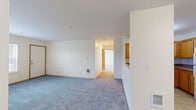 Located at 3045 Gehlar Rd NW in Salem, Oregon, this one-bedroom, two-bathroom unit offers a practical and well-organized single-floor layout. The open-concept kitchen and living area serves as the heart of the home, featuring a peninsula with a sink that overlooks the carpeted living space — ideal for both everyday living and entertaining. The kitchen is equipped with warm honey-toned cabinetry, ample upper and lower storage, and white appliances including a refrigerator, electric range, microwave, and dishwasher, all set atop easy-care tile flooring. The living room is generously proportioned with soft gray carpet, neutral cream walls, and a window that invites natural light. The bedroom is a comfortable, well-lit retreat with large windows framing views of the surrounding greenery, continuing the same plush carpet and clean neutral palette found throughout the unit. Two full bathrooms provide added convenience; both feature warm wood-toned vanities with single-basin sinks, large mirrors with overhead lighting, and tile flooring. One bathroom includes a shower-tub combination. The overall aesthetic is clean and understated, offering a functional and move-in-ready living environment.