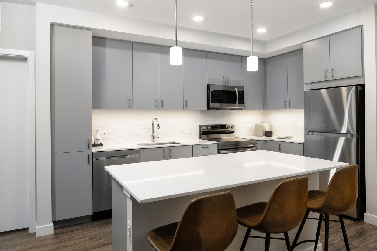 Modern kitchens with light grey cabinetry, white quartz countertops, stainless steel appliances, and hard surface flooring - Avalon Brighton