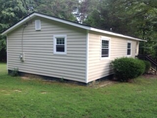 Esta es una toma lateral de la casa que muestra las nuevas ventanas y el revestimiento exterior. - 2680 Ballsville Road