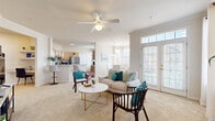 Located at 825 Beverley Dr in Charlottesville, VA, this well-appointed 2-bedroom, 2-bathroom single-floor residence offers a thoughtfully designed layout with a bright, open feel throughout. The combined living and dining area serves as the heart of the home, featuring plush carpeting, a ceiling fan, and large French doors that flood the space with natural light and provide outdoor access. A dedicated dining nook with bay windows and a chandelier adds an elegant touch for everyday meals.

The kitchen is equipped with light wood cabinetry, stone-look countertops, stainless steel appliances, and wood-look plank flooring, complemented by a pendant light and a window overlooking the outdoors. A breakfast bar provides additional seating.

The generously sized primary bedroom offers carpeted flooring, a ceiling fan, and direct access to a walk-in closet with built-in shelving. Both bathrooms feature wood-look tile flooring, warm wood vanities, and tub-shower combinations. Additional highlights include a dedicated in-unit laundry room with a full-size washer and dryer, multiple hallways connecting the layout efficiently, and ample closet storage. The home's neutral palette and well-distributed natural light create a clean, welcoming ambiance throughout.