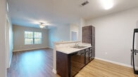 Located at 1414 Alhambra Drive in Lebanon, TN, this single-floor, 2-bedroom, 3-bathroom residence offers a well-organized and functional layout. The open-concept kitchen and living area form the heart of the home, connected by a peninsula with light granite countertops, dark espresso cabinetry, and a built-in sink. The kitchen is fully equipped with black appliances, including a full-size refrigerator, range, and over-the-range microwave, complemented by ample upper and lower cabinet storage. Warm hardwood-style flooring runs throughout the main living areas, enhancing the bright, airy ambiance created by multiple windows. The living room opens naturally from the kitchen, offering a ceiling fan and views to the outdoors. Both bedrooms feature plush carpeting and ceiling fans, with the primary bedroom offering a generously sized footprint. Natural light flows into the bedrooms through large windows with outdoor views. Four closets provide substantial storage throughout the unit. The three bathrooms are finished consistently, each featuring a tub/shower combination, dark vanity cabinetry, granite-style countertops, and safety grab bars. Light hardwood-style flooring ties the bathrooms together with the rest of the home's cohesive aesthetic.