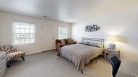 Located at 3 Brentwood Cir in Evansville, Indiana, this efficient one-bedroom, one-bathroom unit offers a thoughtfully arranged single-floor layout. The generously sized bedroom serves as the heart of the space, featuring plush carpeting, multiple windows that invite natural light, and room for a full-size bed, seating, and additional furnishings. A wall-mounted TV, small dining area, and a dedicated workspace are also accommodated within the living area, demonstrating the versatile use of the floor plan.

The kitchen is a standout feature, showcasing gray cabinetry, granite-look countertops, a marble-style tile backsplash, and white appliances including an electric range and over-the-range microwave. Light wood-look flooring ties the kitchen together with a clean, contemporary aesthetic.

The bathroom is finished to a modern standard, with large-format gray wall tiles, a white undermount sink set in a wood-toned vanity, a well-lit mirror with industrial-style fixtures, and a full bathtub. A closet provides dedicated storage to keep the living areas organized. A barn-style sliding door adds a distinctive architectural detail visible in the overall layout. This unit offers a compact yet complete living experience in a well-maintained residential setting.