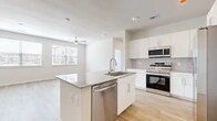 This thoughtfully designed 2-bedroom, 3-bathroom residence offers a bright, open-concept layout with a cohesive modern aesthetic. Light wood-tone flooring flows seamlessly throughout the entire space, creating a warm and airy atmosphere enhanced by neutral wall tones and abundant natural light.

The kitchen serves as a central hub, featuring a large granite-topped island with an undermount sink and integrated dishwasher, crisp white cabinetry, a tile backsplash, and a full suite of stainless steel appliances including a side-by-side refrigerator with ice dispenser, range, microwave, and dishwasher. The kitchen opens directly into the living area, which benefits from a ceiling fan and window views.

Both bedrooms are generously proportioned, each equipped with ceiling fans and access to dedicated closet space. The primary bedroom includes a spacious walk-in closet outfitted with wire shelving systems for organized storage. The bathrooms are finished with marble-look tile surrounds on the tub and shower areas, granite vanity countertops, white cabinetry, and large mirrors. A soaking tub is featured in one of the bathrooms, adding a refined touch.

Overall, the residence presents a clean, contemporary design with consistent finishes that create a cohesive and functional living environment.