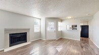 Located at 2624 S Miller Dr in Lakewood, Colorado, this single-story, 2-bedroom, 2-bathroom home offers a well-organized layout with a bright and neutral aesthetic throughout. The living room serves as the heart of the home, featuring wood-style laminate flooring, multiple windows that invite abundant natural light, and a classic brick-surround fireplace that adds warmth and character to the space. The kitchen is thoughtfully designed in a galley configuration, showcasing white cabinetry, light countertops, a stainless steel sink, a dishwasher, and a range, with a window providing natural light and a pass-through that connects it to the living area. A hallway with wood-style flooring leads to the private bedroom wing, where both bedrooms are finished with plush carpeting and neutral gray walls. The primary bedroom includes a spacious walk-in closet with built-in shelving, while the second bedroom features a standard closet. Both bathrooms are clean and functional, with one offering a tub-shower combination, a single vanity with white cabinetry, and wood-style flooring. The home also includes a dedicated laundry area and two closets for additional storage, rounding out a practical and comfortable living space.