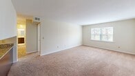 Located at 190 Duke St in Culpeper, Virginia, this single-floor unit offers three bedrooms, one bathroom, and a practical, efficient layout across a compact but well-organized footprint. The interior features a consistent neutral color palette with warm beige walls and wall-to-wall carpeting throughout the living areas and bedrooms, creating a cohesive and understated aesthetic.

The expansive primary bedroom serves as a standout feature, offering generous proportions relative to the overall floor plan, making it a notably comfortable retreat. The two additional bedrooms are each carpeted and equipped with windows that allow natural light to filter in, providing outdoor views of surrounding greenery.

The open-concept living area connects directly to the kitchen via a peninsula-style breakfast bar finished with dark cabinetry and granite countertops, adding a functional and visually distinct focal point to the common space. The kitchen includes standard appliances and a sink integrated into the peninsula.

The full bathroom features a clean, white tub-shower combination with brushed nickel fixtures. A dedicated laundry room houses a full-sized washer and dryer side by side, complemented by overhead shelving for additional storage. A hallway connects the rooms, contributing to a straightforward and accessible floor plan throughout.