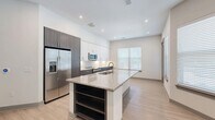 Located at 2650 S McDonald St in McKinney, TX, this well-appointed 2-bedroom, 2-bathroom residence offers a thoughtfully designed single-level layout. Light wood-style flooring runs throughout, complementing the clean, neutral palette that defines the space.

The open-concept living, dining, and kitchen area serves as the heart of the home. The kitchen is a standout, featuring a large granite-topped island with an undermount sink and built-in shelving, two-tone cabinetry with rich dark lower cabinets and crisp white upper cabinets, a herringbone tile backsplash, and a full suite of stainless steel appliances including a French door refrigerator, range, and microwave. Recessed lighting and multiple windows allow natural light to fill the space.

The two bedrooms offer comfortable proportions, with the primary suite featuring a walk-in closet with built-in shelving. The primary bathroom includes a dual-sink vanity with granite countertops, dark cabinetry, a large mirror, and a full tub-shower combination with classic white subway tile. The unit also includes a dedicated laundry area, four closets, a hallway, and a welcoming entrance — providing ample storage and functional flow throughout.