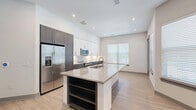 Located at 2650 S McDonald St in McKinney, TX, this well-appointed 2-bedroom, 2-bathroom residence offers a thoughtfully designed single-level layout. Light wood-style flooring runs throughout, complementing the clean, neutral palette that defines the space.

The open-concept living, dining, and kitchen area serves as the heart of the home. The kitchen is a standout, featuring a large granite-topped island with an undermount sink and built-in shelving, two-tone cabinetry with rich dark lower cabinets and crisp white upper cabinets, a herringbone tile backsplash, and a full suite of stainless steel appliances including a French door refrigerator, range, and microwave. Recessed lighting and multiple windows allow natural light to fill the space.

The two bedrooms offer comfortable proportions, with the primary suite featuring a walk-in closet with built-in shelving. The primary bathroom includes a dual-sink vanity with granite countertops, dark cabinetry, a large mirror, and a full tub-shower combination with classic white subway tile. The unit also includes a dedicated laundry area, four closets, a hallway, and a welcoming entrance — providing ample storage and functional flow throughout.