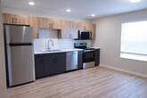 This 370 square foot studio apartment offers a thoughtfully designed living space on a single floor. The open-concept layout combines the kitchen, living room, and sleeping area, maximizing the use of available space. The modern kitchen is a standout feature, boasting sleek stainless steel appliances, including a full-sized refrigerator, oven, and dishwasher. Light wood cabinetry contrasts beautifully with gray lower cabinets, while a white subway tile backsplash adds a clean, contemporary touch.

Throughout the apartment, gleaming hardwood floors create a warm and inviting atmosphere. Large windows allow natural light to flood the space, enhancing the sense of openness. A wall-mounted air conditioning unit provides climate control for year-round comfort.

The bathroom, while compact, is efficiently designed with a single vanity, mirror, and in-unit washer and dryer for added convenience. Recessed lighting and a central ceiling fixture ensure ample illumination throughout the apartment.

Despite its modest size, the apartment's clever layout and modern amenities make it an ideal living solution for singles or couples seeking a comfortable, low-maintenance urban dwelling.