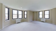Located at 135 South 19th Street in Philadelphia, PA, this single-floor space sits in the heart of the Rittenhouse Square neighborhood. The interior presents an open, airy layout finished with neutral beige walls and soft wall-to-wall carpeting that lends a clean, understated aesthetic throughout. Multiple large windows with black frames line the walls, flooding the space with abundant natural light while offering impressive elevated views of the surrounding Philadelphia cityscape. The windows are arranged along a gently curved wall section, adding a subtle architectural detail that distinguishes the floor plan from a standard rectangular layout. Recessed ceiling lighting complements the natural light, ensuring the space remains well-illuminated at all times. White radiator units beneath the windows provide heating, consistent with the building's classic infrastructure. The smooth white ceiling contributes to the sense of openness and volume within the room. The overall ambiance is calm and neutral, providing a versatile blank canvas well-suited for a variety of uses. The location within Center City Philadelphia places it in close proximity to premier dining, retail, and cultural destinations.