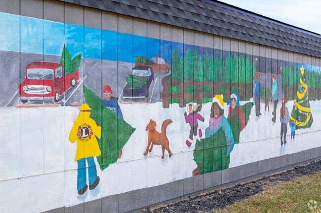 A large Christmas-themed mural adorns the side of a building in Bel Air.