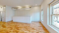 Located at 305 N Second St in Richmond, Virginia, this thoughtfully designed single-floor unit combines modern aesthetics with functional living. Light hardwood floors run throughout, complementing the bright white walls and recessed lighting that create a clean, airy atmosphere across every room.

The kitchen serves as a standout centerpiece, featuring a large island with quartz countertops, an undermount sink with a matte black faucet, white shaker cabinetry, and a full suite of stainless steel appliances including a refrigerator, range, and microwave. Pendant lighting above the island adds a refined touch.

The living and dining areas offer generous open space, with natural light streaming in through double-hung windows that frame views of the surrounding Richmond streetscape. A half-wall partition helps define the layout while maintaining an open, connected feel.

The bedrooms are well-proportioned and bright, with large windows allowing abundant natural light. One bedroom features a stylish sliding barn door, adding a contemporary architectural detail. Additional rooms provide flexible use as offices or storage.

The bathroom is finished to a high standard, with marble-style tile in the walk-in glass shower, hexagonal mosaic floor tile, a white vanity with quartz countertop, and matte black hardware throughout — delivering a cohesive, modern design sensibility.