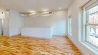 Located at 305 N Second St in Richmond, Virginia, this thoughtfully designed single-floor unit combines modern aesthetics with functional living. Light hardwood floors run throughout, complementing the bright white walls and recessed lighting that create a clean, airy atmosphere across every room.

The kitchen serves as a standout centerpiece, featuring a large island with quartz countertops, an undermount sink with a matte black faucet, white shaker cabinetry, and a full suite of stainless steel appliances including a refrigerator, range, and microwave. Pendant lighting above the island adds a refined touch.

The living and dining areas offer generous open space, with natural light streaming in through double-hung windows that frame views of the surrounding Richmond streetscape. A half-wall partition helps define the layout while maintaining an open, connected feel.

The bedrooms are well-proportioned and bright, with large windows allowing abundant natural light. One bedroom features a stylish sliding barn door, adding a contemporary architectural detail. Additional rooms provide flexible use as offices or storage.

The bathroom is finished to a high standard, with marble-style tile in the walk-in glass shower, hexagonal mosaic floor tile, a white vanity with quartz countertop, and matte black hardware throughout — delivering a cohesive, modern design sensibility.
