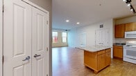 Located at 4729 Grand Ave NE in Columbia Heights, Minnesota, this well-appointed two-bedroom, two-bathroom residence offers a thoughtfully designed single-floor layout. The open-concept kitchen and living area serves as the heart of the home, anchored by a large granite-topped island with warm wood cabinetry. The kitchen is fully equipped with ample upper and lower cabinetry, granite countertops, a dishwasher, and track lighting overhead, creating a functional and inviting cooking space. Hardwood-style flooring extends throughout the main living areas, adding warmth and continuity to the open floor plan. Large windows in the living area flood the space with natural light and offer views of the surrounding neighborhood. The primary bedroom features plush carpeting, a sizable window with outdoor views, and generous closet storage. The second bedroom is similarly carpeted and bright, with large windows overlooking the exterior. Both bathrooms are finished with wood-toned vanities, hardwood-style flooring, and tub-shower combinations with accessibility grab bars. A dedicated in-unit laundry area adds everyday convenience. With five closets throughout, storage is plentiful. The overall aesthetic is clean, modern, and move-in ready.