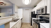 This well-appointed 2-bedroom, 3-bathroom residence in Lakewood, Colorado offers a thoughtfully designed single-level layout with a neutral gray color palette and a mix of carpet and wood-look flooring throughout. The galley-style kitchen features white cabinetry, light quartz-style countertops, stainless steel appliances including a refrigerator, range, microwave, and dishwasher, all set against easy-care hard-surface flooring. Adjacent to the kitchen, the dining area includes a built-in desk nook and ceiling fan, providing a functional space for both meals and work. The living room is bright and welcoming, with large windows and glass patio doors that invite natural light and outdoor access. Both bedrooms are carpeted and comfortably sized, with the primary bedroom offering a generous footprint, natural light from large windows, and access to a private closet. Three full bathrooms include tiled tub/shower combinations with clean white finishes. A dedicated in-unit laundry area accommodates a full-sized washer and dryer. A central hallway connects all rooms efficiently, completing a practical and comfortable floor plan ideally situated in the Lakewood community.