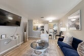 Located at 11000 Point Sylvan Circle in Orlando, FL, this well-designed single-floor residence makes smart use of its space through a thoughtful, open-concept layout. Light wood-style flooring flows throughout, lending a cohesive and airy feel to every room.

The combined living, dining, and kitchen area forms the heart of the home. The kitchen features white cabinetry, light quartz countertops with a peninsula breakfast bar, stainless steel appliances including a refrigerator, range, and built-in microwave, and track lighting overhead. The living area offers generous natural light and a neutral color palette, while the adjacent dining space provides a seamless flow for everyday living and entertaining.

The bedroom is a calm retreat, equipped with a ceiling fan and windows that bring in natural light and outdoor views. A full bathroom with white vanity cabinetry, a framed mirror, and wood-style flooring is conveniently accessible.

A separate den offers flexibility as a home office or additional living space, highlighted by large windows, sheer curtains, and a ceiling fan. An in-unit laundry area adds everyday convenience. Two closets and a hallway complete the functional layout of this well-appointed Orlando residence.