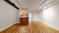 Located at 7–9 O Henry Ave in the heart of Asheville, NC, this one-bedroom, one-bathroom residence offers a thoughtfully designed single-floor layout with a blend of industrial character and modern comfort. The open-concept living and kitchen area is a standout feature, anchored by warm hardwood floors, exposed ceiling beams, and sleek track lighting that runs throughout. A bank of large shuttered windows and a glass-paned door flood the living space with natural light while offering privacy control, and a ceiling fan adds to the room's airy feel. The kitchen is well-appointed with rich wood cabinetry, granite countertops, stainless steel appliances, and a peninsula that provides both prep space and a natural dividing point between the kitchen and living area. The spacious bedroom is finished with plush wall-to-wall carpeting and soaring high ceilings, creating a calm and generous retreat. A dedicated closet provides ample storage. The bathroom features white cabinetry with a single-basin vanity, a framed wood mirror, and clean tile flooring, offering a bright and functional design. A dedicated laundry area and hallway round out this well-organized, efficiently laid-out home in one of Asheville's vibrant neighborhoods.