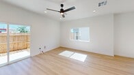 Located on Harry Miller Pass in Seguin, TX, this two-story home offers a clean, modern aesthetic across three bedrooms and three bathrooms. The main floor provides a generous open-concept living area bathed in natural light, with light wood-look flooring, recessed lighting, and a ceiling fan that contribute to a bright and airy atmosphere. Sliding glass doors open directly to a private, fenced backyard patio, seamlessly extending the living space outdoors.

The kitchen is well-appointed with crisp white shaker cabinetry, black hardware accents, white subway tile backsplash, quartz countertops, stainless steel appliances, and a dedicated pantry closet — combining style and practicality. The bathrooms continue the modern theme with white vanities, black fixtures, and subway-tiled walk-in showers.

The bedrooms are thoughtfully finished: main-floor rooms feature light wood flooring and multiple windows for ample natural light, while upper-floor bedrooms are carpeted for comfort and include closets with built-in hanging rods. The primary bedroom connects directly to an en suite bathroom. Throughout, the home maintains a consistent palette of crisp white walls, black hardware, and warm wood tones, creating a cohesive and contemporary living environment.