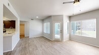 Located at 1600 W La Jolla Dr in Tempe, AZ, this single-story residence offers four bedrooms and three bathrooms within a thoughtfully laid-out floor plan. Light-toned wood-look flooring runs consistently throughout the home, creating a clean and cohesive aesthetic. The combined kitchen and living area serves as the heart of the home, where the kitchen stands out with rich dark-stained cabinetry, stainless steel appliances including a refrigerator, range, and microwave, light quartz countertops, a peninsula with a undermount sink, and a full-height pantry cabinet for ample storage. The living area benefits from natural light through a large window and sliding door that opens to the outdoors, complemented by a ceiling fan overhead. Each bedroom is bright and airy, featuring ceiling fans, wood-look flooring, and windows with views of the surrounding greenery. The primary bedroom offers a generous footprint. The three bathrooms are finished consistently with dark vanity cabinetry, white countertops, wood-look tile flooring, and tub-shower combinations with tiled surrounds and chrome fixtures. A dedicated laundry room houses a full-size washer and dryer alongside a water heater, adding everyday convenience to this well-appointed Tempe residence.