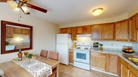 Located at 3451 E. Livingston Ave in Columbus, Ohio, this multi-story property spans three floors and offers a practical, well-maintained layout. The kitchen is equipped with warm oak cabinetry, granite-style countertops, a full suite of white appliances including a refrigerator and electric range, and durable tile flooring. An adjacent dining area provides a comfortable space for meals, featuring a ceiling fan with light fixture and a window that lets in natural light. The carpeted bedrooms are generously sized, each featuring ceiling fans and ample closet space with built-in shelving and hanging rods. One bedroom benefits from a large window overlooking the outdoors. The bathroom includes tile flooring, a shower with a tub, and a wood-toned vanity countertop. The main living area offers a cozy sitting space with carpet flooring, staircase access, and room for flexible furniture arrangements. The finished basement provides additional living space, complete with carpeting, paneled walls, overhead lighting, and a small window, making it suitable for use as a recreation or lounge area. Throughout the home, neutral tones and consistent finishes create a cohesive and functional atmosphere across all three levels.