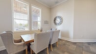 Located at 1709 Cason Lane in Murfreesboro, Tennessee, this single-room professional space offers a refined and functional environment ideal for meetings or consultations. The room is finished with warm, neutral-toned walls and crown molding that lend a polished, classic character throughout.

At the heart of the space sits a solid wood farmhouse-style conference table surrounded by upholstered wingback chairs in soft gray linen, creating a comfortable yet professional setting. A large decorative Roman numeral wall clock serves as a standout accent piece, adding warmth and a timeless aesthetic to the room.

Two sets of windows fitted with white horizontal blinds allow generous natural light to fill the space while maintaining privacy. The patterned carpet tile flooring adds texture and a contemporary contrast to the traditional furnishings.

A pair of glass-paneled double doors provides entry and connects the room to an adjacent area, contributing to an open and accessible feel. Additional seating in the form of tufted dark leather chairs near the entrance offers a functional waiting or secondary seating area. Crown molding and clean white baseboards throughout complete the well-maintained, professional finish of this inviting space.