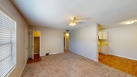 Located at 715 Marie Antoinette St. in Lafayette, Louisiana, this single-story residence offers three bedrooms, two bathrooms, and a practical, well-organized layout. The living area features neutral-toned carpet, a ceiling fan with light fixture, and a textured ceiling, creating a comfortable and functional space. An open sightline connects the living area to the galley-style kitchen, which is equipped with white cabinetry, light wood-toned countertops, hardwood-style flooring, a double sink, an electric range, a built-in microwave, and a refrigerator — providing ample workspace and storage. The spacious primary bedroom includes a ceiling fan, carpeted flooring, and a dedicated closet. The additional bedrooms are similarly carpeted, each with ceiling fans, and one features its own walk-in closet. Three closets in total offer generous storage throughout the home. Both bathrooms include a tub-shower combination with built-in shelving, complemented by clean, simple finishes. A central hallway connects the rooms efficiently. Throughout the home, a consistent palette of neutral tones and practical materials creates a cohesive, move-in-ready atmosphere suitable for a variety of living arrangements.