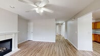 Located at 5220 Plank Rd in Halfmoon, NY, this single-floor, 2-bedroom, 2-bathroom residence offers a clean, neutral aesthetic throughout. Light hardwood-style flooring runs continuously across the main living areas, complementing the soft gray and beige wall tones that give the space a bright, cohesive feel.

The living room serves as a central gathering area and features a white-mantled fireplace as a focal point, along with a ceiling fan with integrated lighting. The entry foyer is finished with tile flooring and includes windows that allow natural light to filter in directly upon arrival.

The kitchen is equipped with warm oak-toned cabinetry, white appliances including a range, microwave, dishwasher, and refrigerator, and a functional U-shaped layout with ample counter and storage space.

Both bedrooms feature the same hardwood-style flooring and windows with blinds that frame views of surrounding greenery, providing natural light and privacy. The primary bedroom offers a comfortable, well-proportioned layout. Each of the two bathrooms includes a full tub-shower combination with white surround panels, maintaining the home's consistent, practical design throughout.