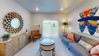 This 880 square foot apartment, known as the Juniper model, offers a thoughtfully designed living space on a single floor. The layout features two bedrooms and two bathrooms, providing comfort and privacy. The primary bedroom, measuring 150 square feet, offers ample space for relaxation.

The modern kitchen is a standout feature, boasting rich wood cabinetry, stainless steel appliances, and a subway tile backsplash. Granite countertops and a central island provide both functionality and style. The open-concept design seamlessly connects the kitchen to the living area, creating an ideal space for entertaining.

Both bathrooms are well-appointed with granite vanity tops, large mirrors, and a combination of wood flooring and carpeting. The unit includes an in-unit washer and dryer, adding convenience to daily life.

Throughout the apartment, you'll find stylish finishes and decor, including contemporary light fixtures, artistic wall hangings, and a mix of modern and rustic furniture pieces. Large windows in every room allow for ample natural light, while also offering views of the surrounding area.

The living room features plush carpeting, a comfortable seating area, and sliding glass doors that likely lead to an outdoor space. A small office nook with a rustic wooden desk provides a dedicated workspace within the apartment.

Overall, the Juniper model combines efficiency and style, offering a comfortable living environment in a compact yet well-designed space.