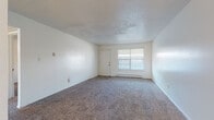 Located at 1602 NW 31st St in Oklahoma City, Oklahoma, this single-floor unit offers a straightforward and functional layout well-suited for comfortable everyday living. The spacious living area is finished with neutral-toned carpet and features a textured ceiling, baseboard heating, and a window that invites natural light into the room. An open passage connects the living area to a secondary space, also carpeted, with a ceiling fan and access to additional rooms. The galley-style kitchen is equipped with white cabinetry, laminate countertops, a stainless steel sink, and white appliances including a range and refrigerator. Wood-look vinyl flooring and a window overlooking the exterior complete the kitchen's clean, practical aesthetic. The bedrooms are carpeted and well-lit, each featuring windows with blinds and baseboard heating units. One bedroom includes a closet with a hanging rod for storage. The bathroom offers a tub and shower combination with tiled surround and wood-look vinyl flooring. Throughout the unit, the clean white walls and consistent finishes create a bright, cohesive atmosphere ready for personalization.